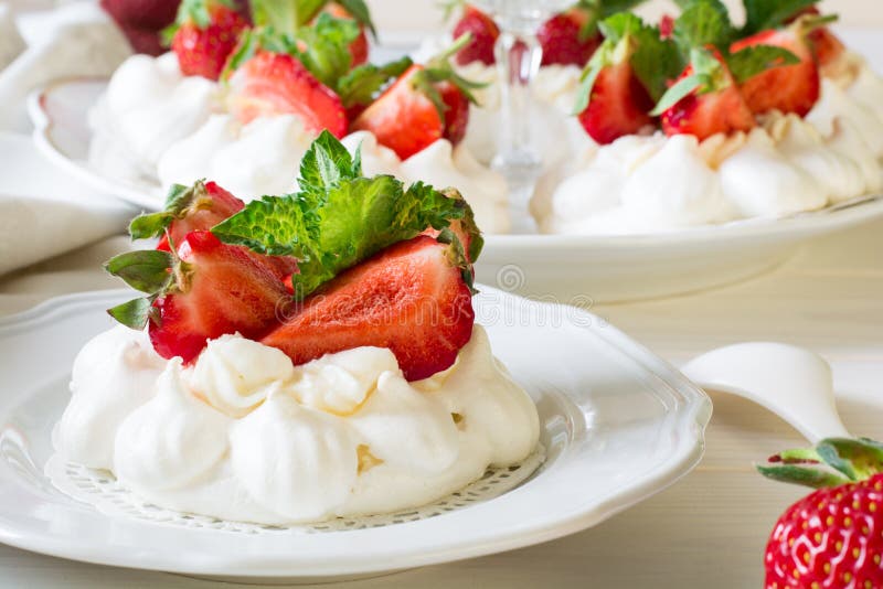 Домодельная малая меренга pavlova клубники испечет с листьями сливк mascarpone и свежей мяты стоковое фото Домодельная малая меренга pavlova клубники испечет с листьями сливк mascarpone и свежей мяты стоковое фото