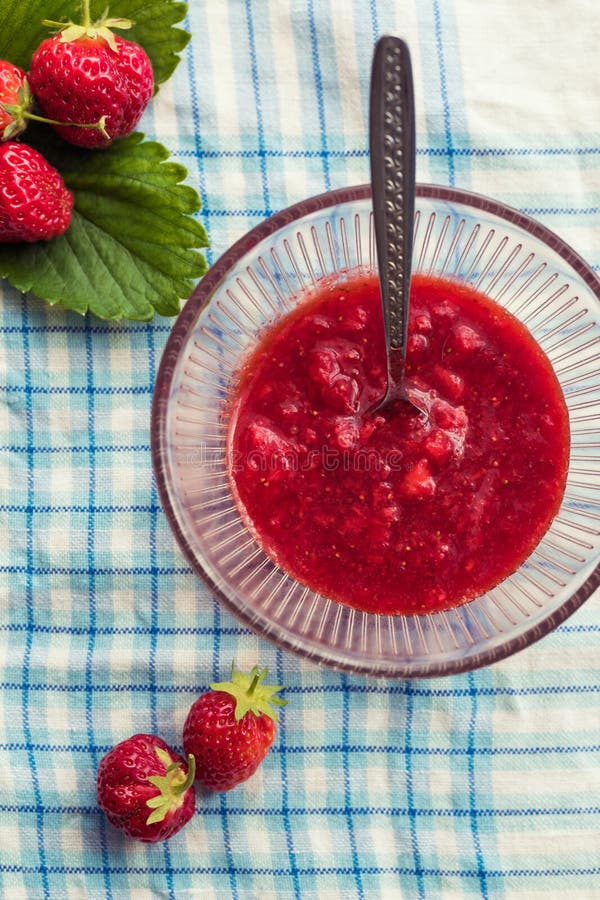 Домодельное варенье клубники (marmelade) стеклянный шар с горячим вареньем и свежими клубниками стоковое изображение
