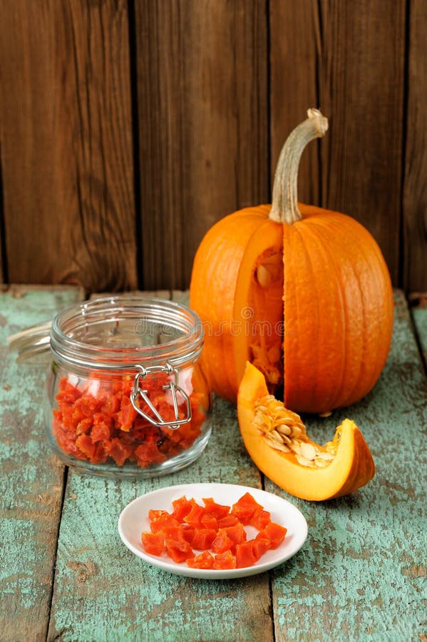 Домодельные candied части тыквы в стеклянном опарнике и белом острословии плиты стоковые изображения rf Домодельные candied части тыквы в стеклянном опарнике и белом острословии плиты стоковые изображения rf