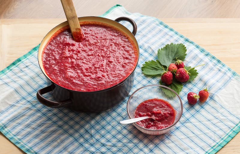 Домодельный варить варенья клубники (marmelade) Большой бак с горячим вареньем и свежими клубниками стоковые изображения rf