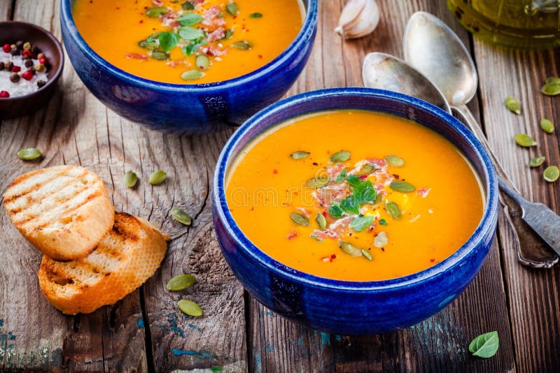 Домодельный суп сквоша butternut осени с семенами, беконом и базиликом тыквы стоковое изображение rf Домодельный суп сквоша butternut осени с семенами, беконом и базиликом тыквы стоковое изображение rf