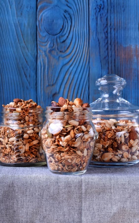 Домодельный granola с различными гайками и семенами в стеклянных опарниках стоковое фото rf Домодельный granola с различными гайками и семенами в стеклянных опарниках стоковое фото rf