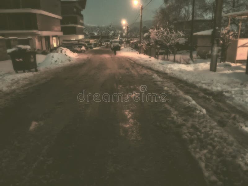Дорога, частично освобоженная снега Трассировки автошин от автомобиля в снеге Начало зимы в Bakuriani
