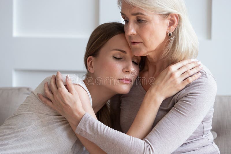 Loving senior mother put grownup daughter to chest caressing comforting after relationships drama, caring mature mom parent hug embrace adult upset woman child cuddling showing support. Loving senior mother put grownup daughter to chest caressing comforting after relationships drama, caring mature mom parent hug embrace adult upset woman child cuddling showing support