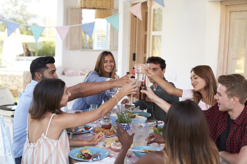 Друзья делая здравицу на официальныйе обед на патио, Ibiza стоковые изображения Друзья делая здравицу на официальныйе обед на патио, Ibiza стоковые изображения