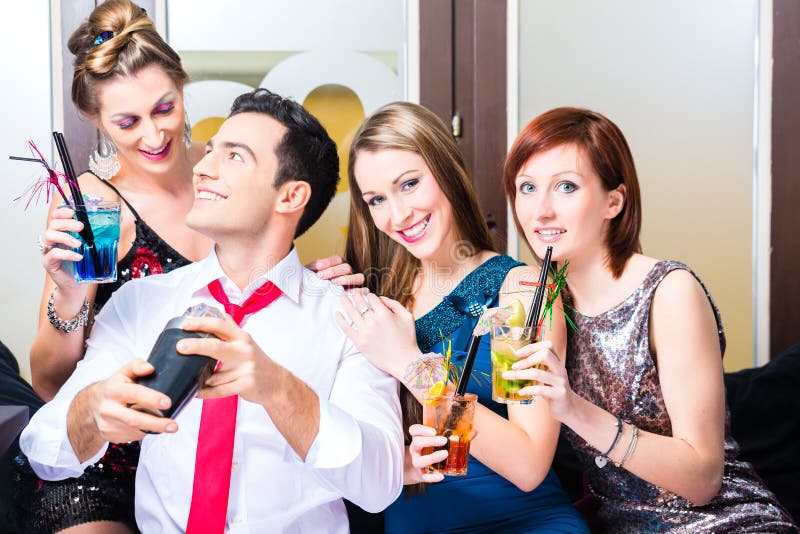 Друзья празднуя с barkeeper в коктейль-баре стоковые фото Друзья празднуя с barkeeper в коктейль-баре стоковые фото