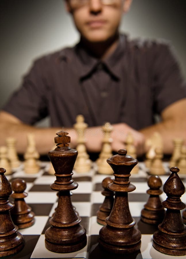 Chess master thinking before making a move (shallow Dof, focus on front chess piece). Chess master thinking before making a move (shallow Dof, focus on front chess piece)