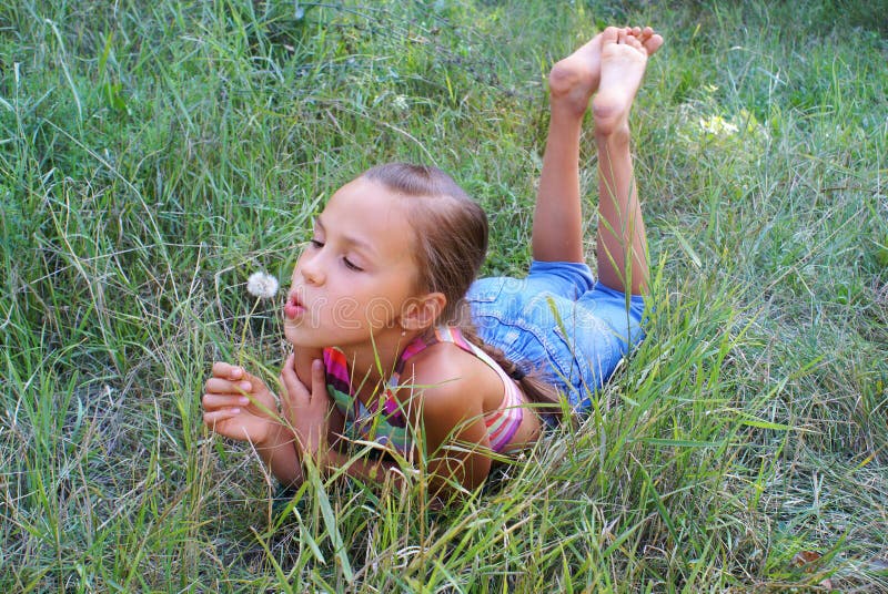 дуя preteen девушки одуванчика стоковое фото rf дуя preteen девушки одуванчика стоковое фото rf