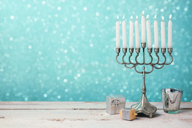 Еврейское торжество Хануки праздника с menorah, dreidel и подарками на деревянном столе Еврейское торжество Хануки праздника с menorah, dreidel и подарками на деревянном столе