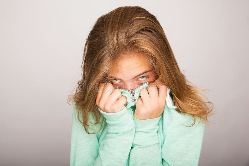 A shy teenage girl trying to hide her face. A shy teenage girl trying to hide her face