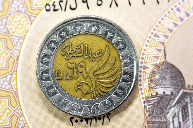 Obverse side of Egyptian 1 LE EGP One Egyptian pound coin on Egyptian banknote, Translation of Arabic (Police day 69 years) in the memorial of Egypt police day with a flying falcon. Obverse side of Egyptian 1 LE EGP One Egyptian pound coin on Egyptian banknote, Translation of Arabic (Police day 69 years) in the memorial of Egypt police day with a flying falcon