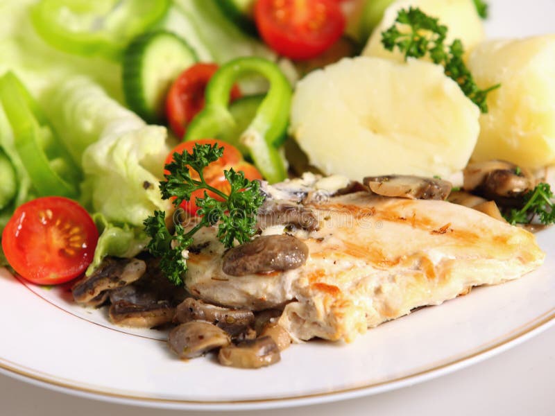 A meal of marinaded, grilled chicken breast with mushrooms, salad and potato. A meal of marinaded, grilled chicken breast with mushrooms, salad and potato.