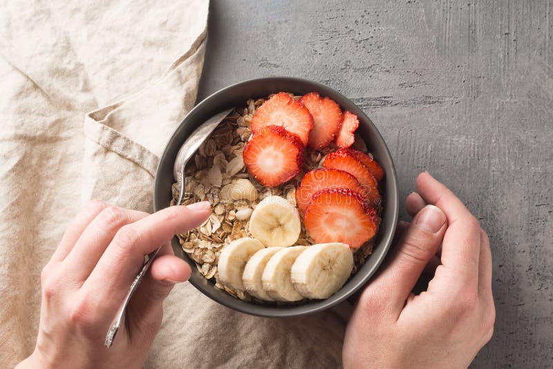 Еда здорового шара завтрака Muesli и свежие фрукты в керамическом шаре в руках ` s женщины Чистая еда, dieting, вытрезвитель, veg стоковое фото Еда здорового шара завтрака Muesli и свежие фрукты в керамическом шаре в руках ` s женщины Чистая еда, dieting, вытрезвитель, veg стоковое фото