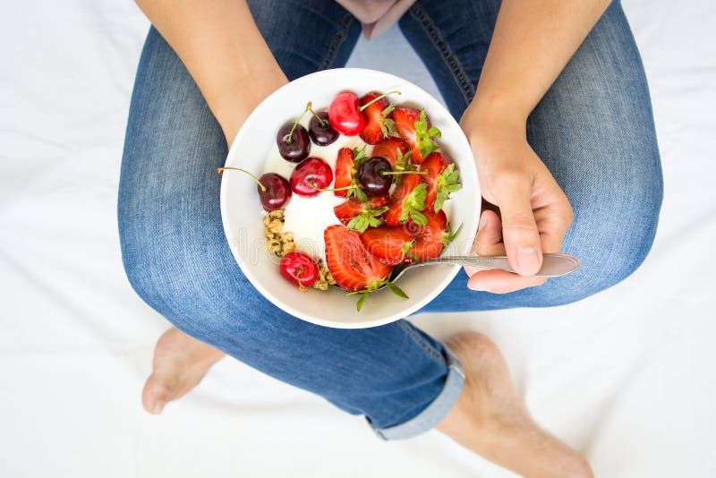 еда принципиальной схемы здоровая ` S женщин вручает держать шар с muesli, югуртом, клубникой и вишней Взгляд сверху lifestyle стоковые фотографии rf еда принципиальной схемы здоровая ` S женщин вручает держать шар с muesli, югуртом, клубникой и вишней Взгляд сверху lifestyle стоковые фотографии rf