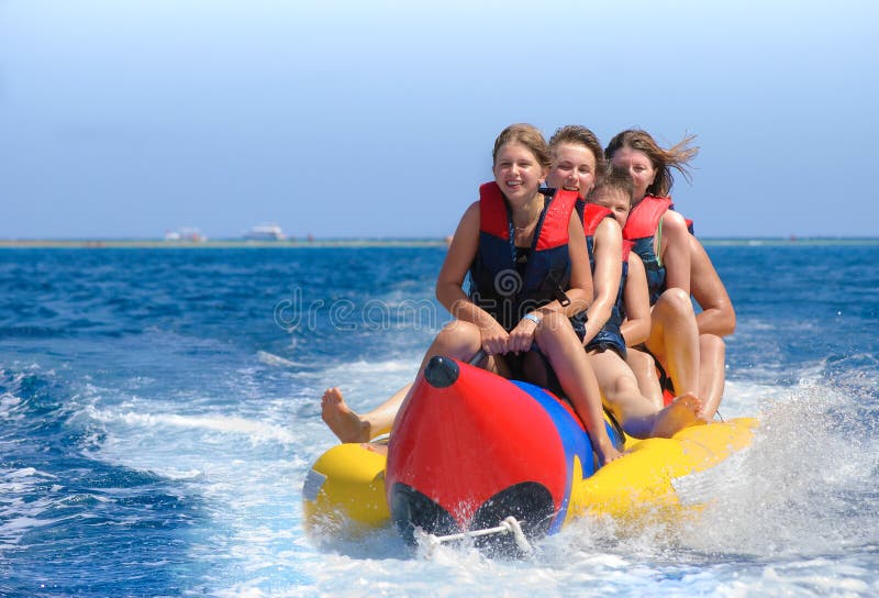 People ride on banana boat. Bright blue sea and clear sky. Happy vacation. People ride on banana boat. Bright blue sea and clear sky. Happy vacation.