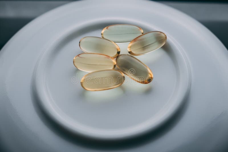Желтые прозрачные капсулы omega 3 стоковое изображение