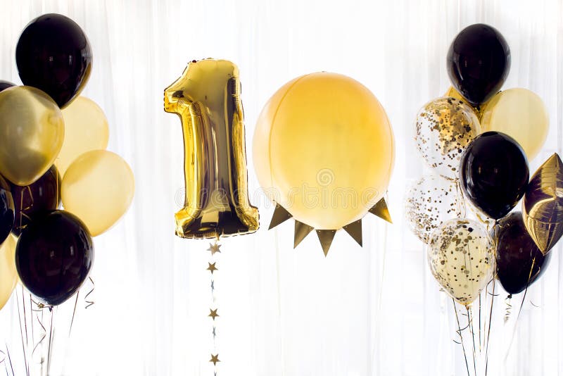 Golden yellow black holiday balloons in form of number ten 10 on white background. Golden yellow black holiday balloons in form of number ten 10 on white background