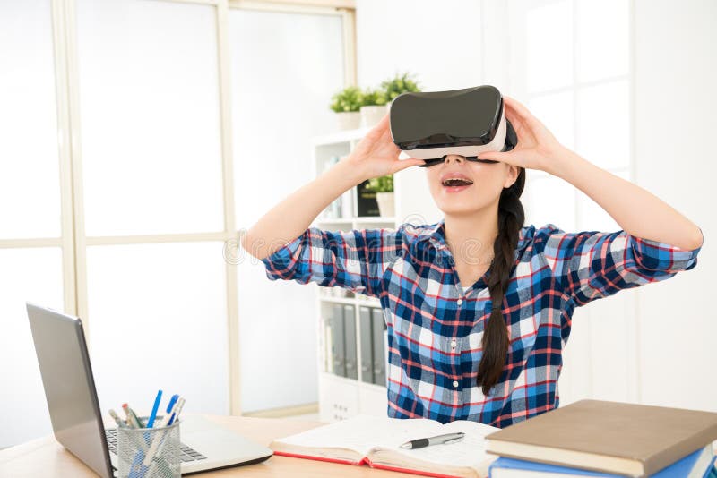 Женская девушка в рубашке держа прибор VR стоковые изображения rf Женская девушка в рубашке держа прибор VR стоковые изображения rf