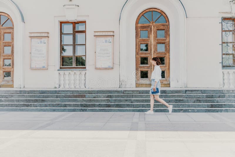 женская лестница. бизнес-леди в белой рубашке и джинсовой юбке идет по ступенькам старинного здания стоковые фото