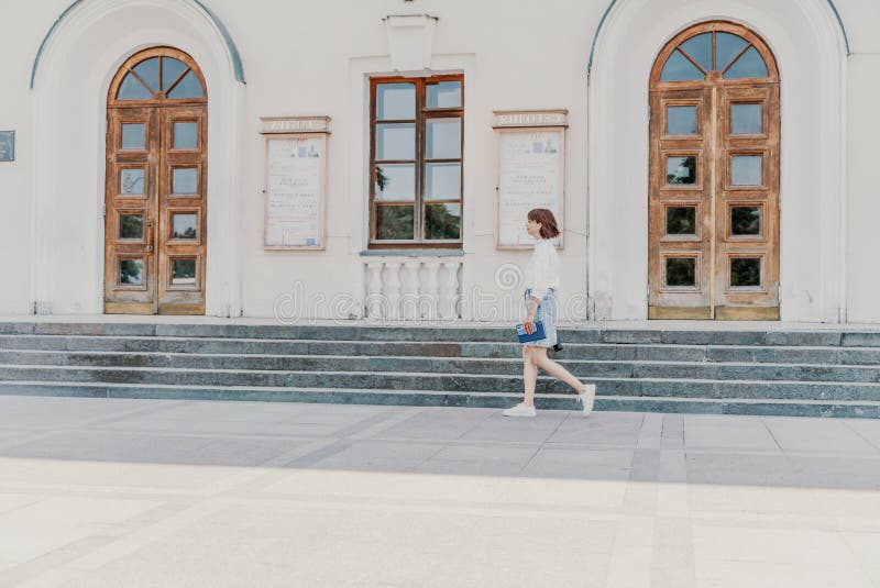женская лестница. бизнес-леди в белой рубашке и джинсовой юбке идет по ступенькам старинного здания стоковое изображение rf