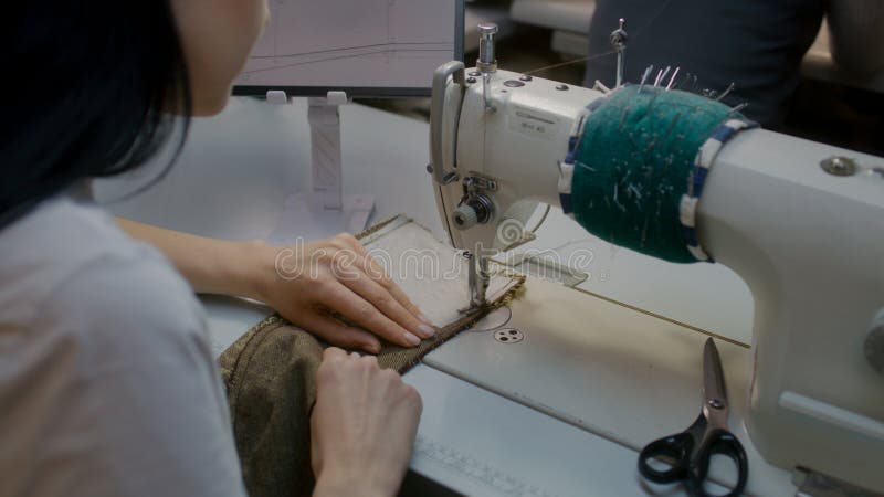 женская швея или портниха работает в элегантном свадебном костюме стоковое изображение