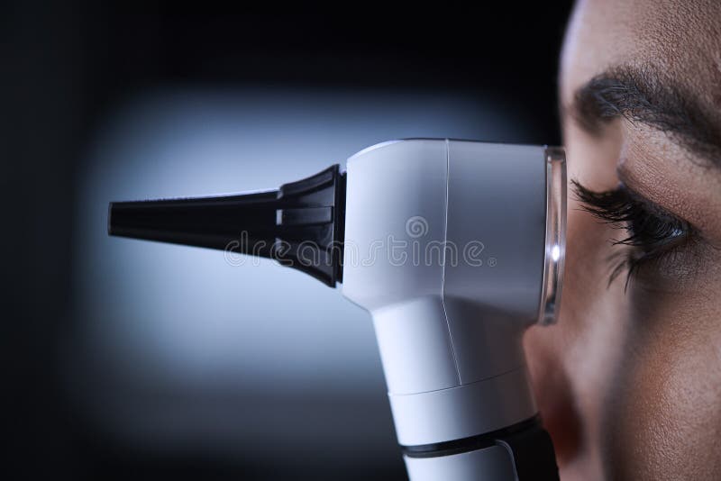 Женский доктор используя otoscope, взгляд со стороны, конец вверх стоковые изображения rf