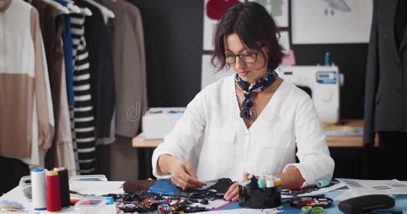Женский конструктор, работающих с швейных аксессуаров в ателье