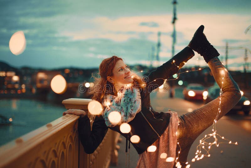 Женщина Redhead при света гирлянды fairy делая стиль йоги винтажный стоковое фото Женщина Redhead при света гирлянды fairy делая стиль йоги винтажный стоковое фото