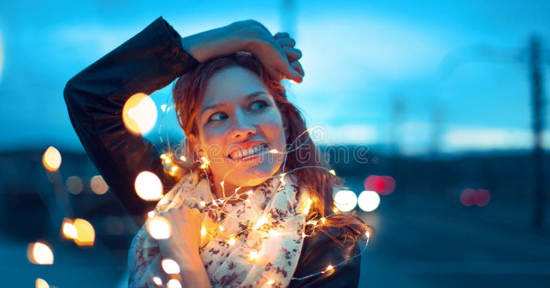 Женщина Redhead при света гирлянды fairy смотря прочь стоковые фото Женщина Redhead при света гирлянды fairy смотря прочь стоковые фото