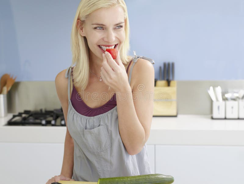 Женщина Snacking на томате вишни стоковое изображение Женщина Snacking на томате вишни стоковое изображение