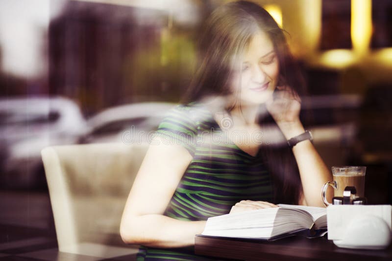 Женщина брюнет сидя на кофе книги чтения кафа, studing и выпивать стоковое изображение Женщина брюнет сидя на кофе книги чтения кафа, studing и выпивать стоковое изображение