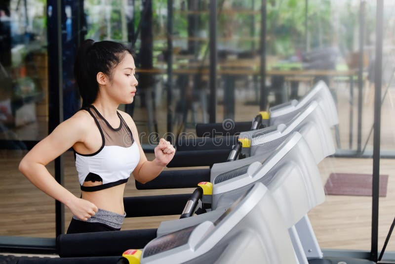 Женщина в sportswear бежать на третбане на спортзале, концепции cadio стоковые фото Женщина в sportswear бежать на третбане на спортзале, концепции cadio стоковые фото