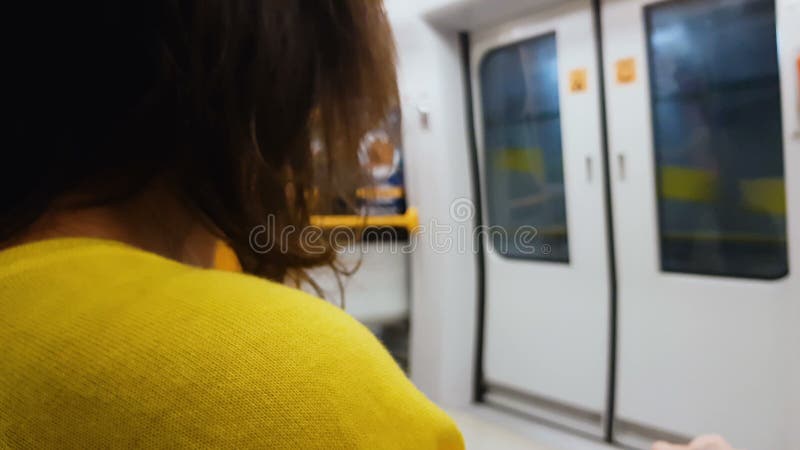 Женщина в желтой блузке получая домашний поезд, образ жизни приедаемости, общественный транспорт