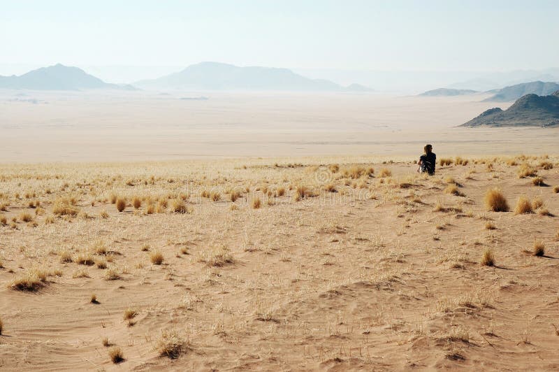 Woman look at the desert - Desert Mountains background. Namibia, Deadvlei, Sossuvlei. Woman look at the desert - Desert Mountains background. Namibia, Deadvlei, Sossuvlei.