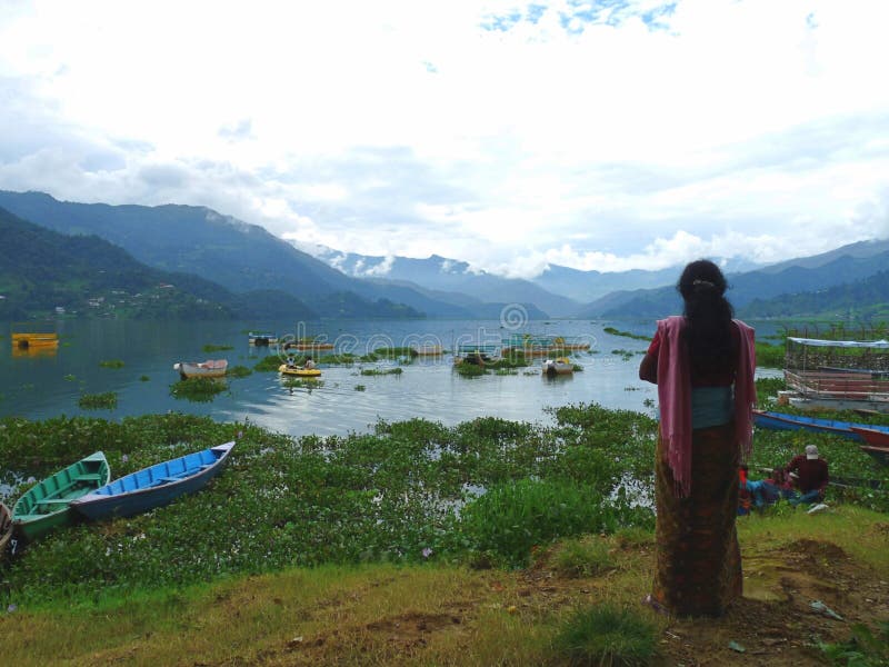 Женщина, восхищаясь pokhara Непал озера phewa с гор в фоновом режиме стоковое изображение