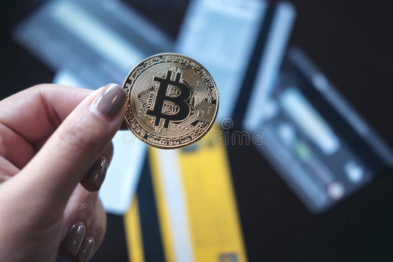Женщина держа золотое bitcoin цвета с много кредитных карточек на таблице в офисе стоковые фото Женщина держа золотое bitcoin цвета с много кредитных карточек на таблице в офисе стоковые фото