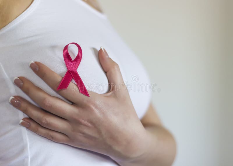 Woman hold her breast and have sign for breast cancer on it. Copy space available. Woman hold her breast and have sign for breast cancer on it. Copy space available.