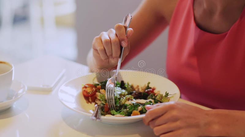 Женщина есть салат для обеда на ресторане