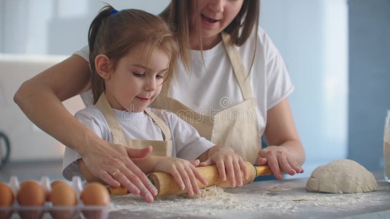 Женщина и девочка юркнуть яйца на кухне. Дочь и мать готовит вместе сток-видео