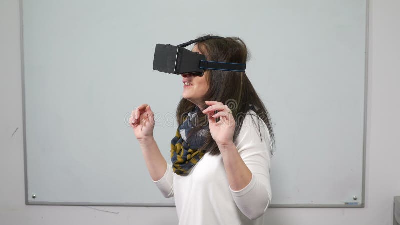 Женщина играя видеоигру с шлемофоном оборудования VR специальным во время испытания акции видеоматериалы Женщина играя видеоигру с шлемофоном оборудования VR специальным во время испытания акции видеоматериалы