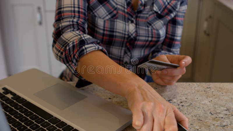 Женщина используя телефон и компьтер-книжку