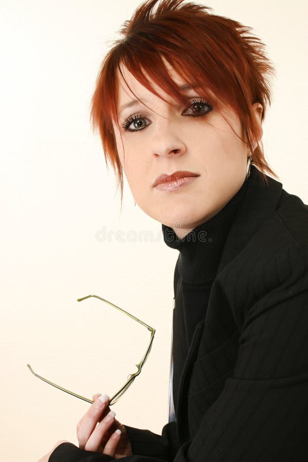 Attractive 30 year old woman with serious expression holding glasses in suit. Attractive 30 year old woman with serious expression holding glasses in suit.