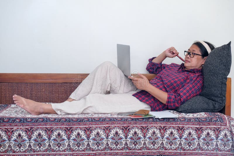 женщина, лежащая на диване во время работы в офисе стоковая фотография