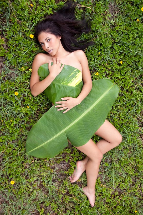 woman covered with banana leaf. woman covered with banana leaf