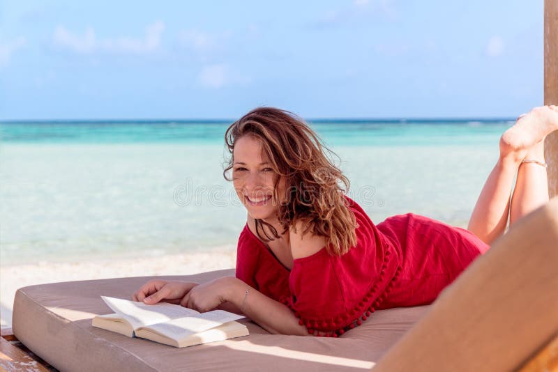 Женщина на sunchair читая книгу в тропическом положении Ясная вода бирюзы как предпосылка стоковое фото Женщина на sunchair читая книгу в тропическом положении Ясная вода бирюзы как предпосылка стоковое фото