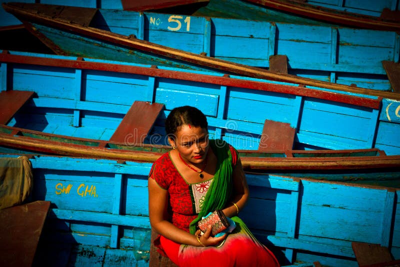 Женщина непальца сидя в шлюпках озера Phewa, Pokhara, Непала стоковые фото