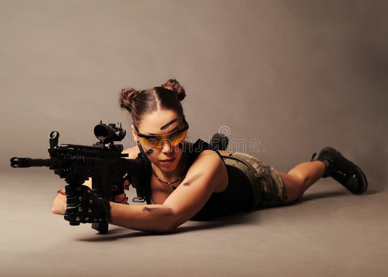 army woman posing with weapon, on gray background. army woman posing with weapon, on gray background.