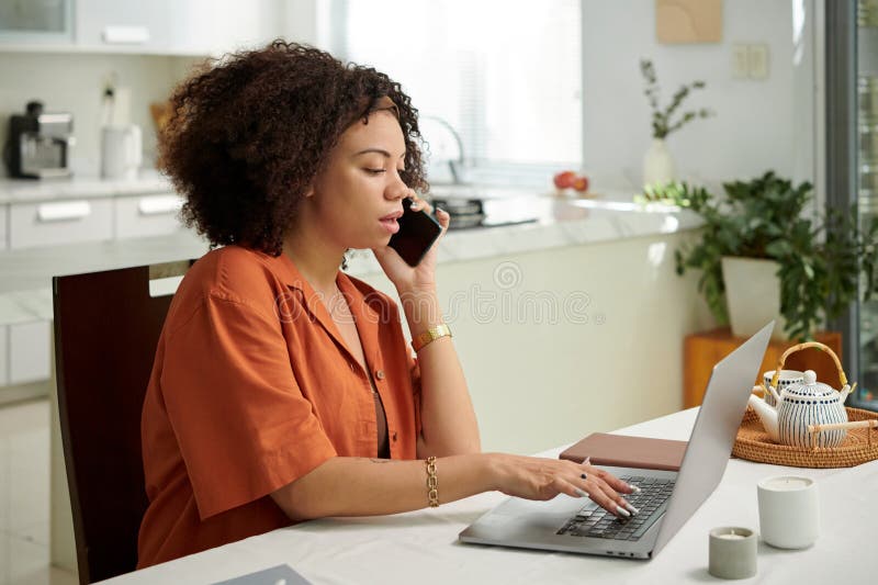 Portrait of Latin woman answering phone calls and e-mails when working from home. Portrait of Latin woman answering phone calls and e-mails when working from home