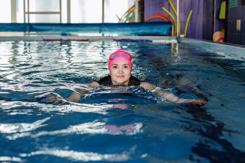 женщина плавает в бассейне. очки и плавательная шапка. концепция спорта .