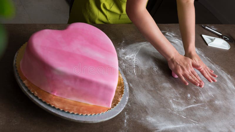 Женщина подготавливая королевскую замороженность для украшать свадебного пирога